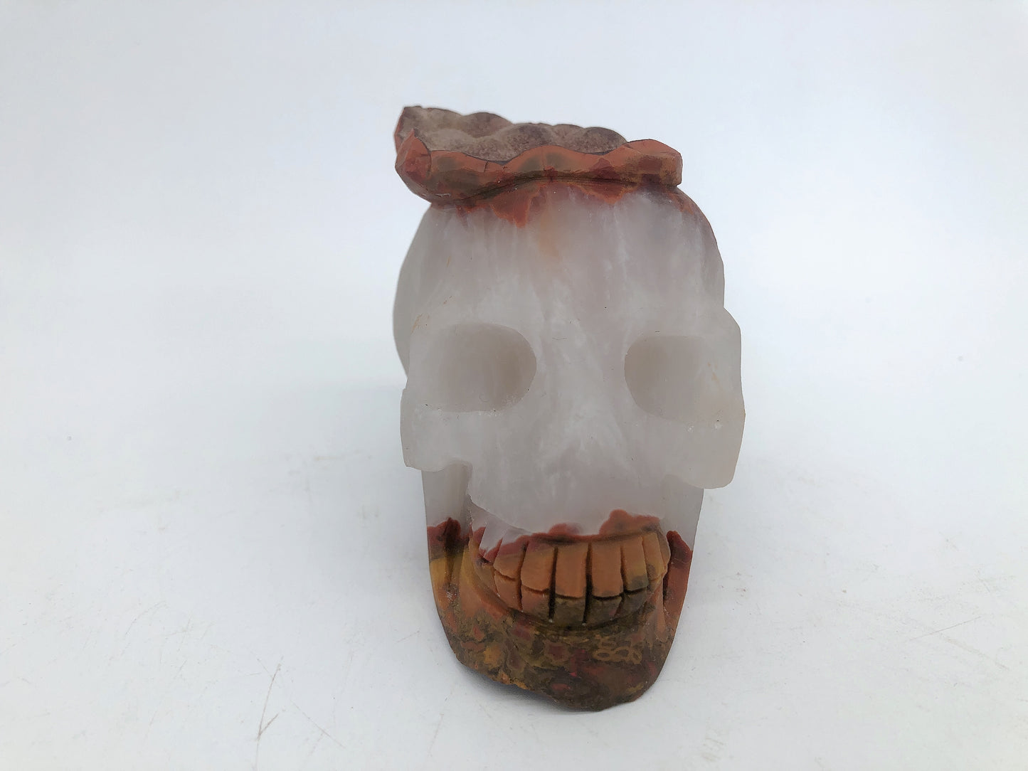 Clear quartz with red jasper skull carving