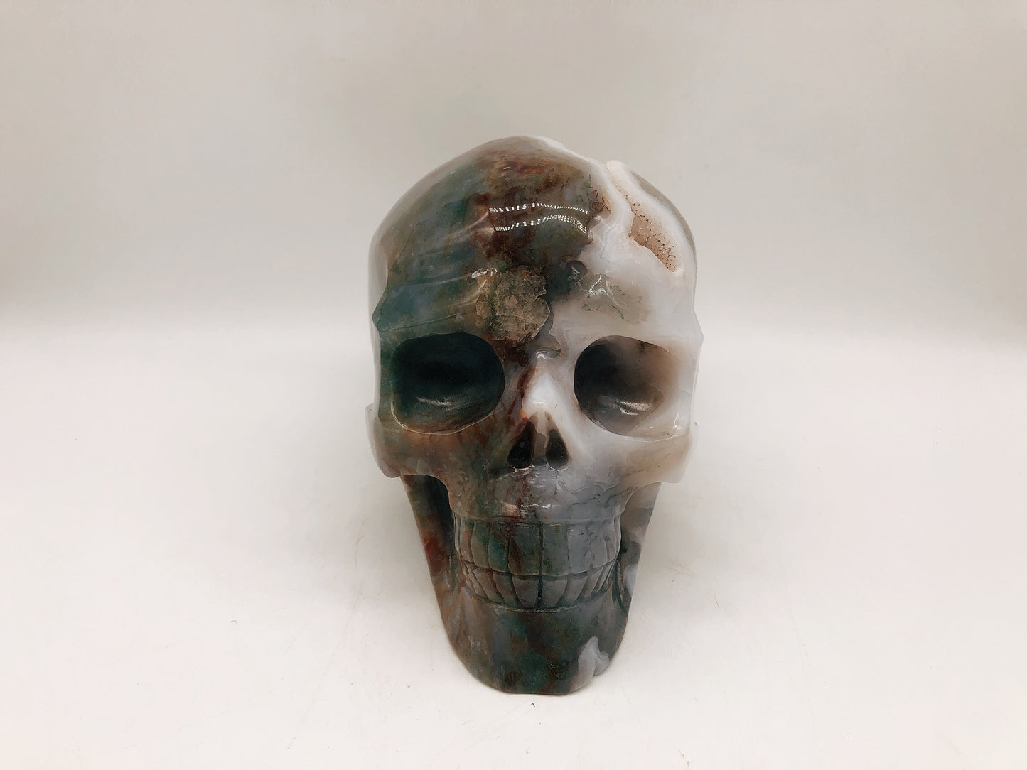 Moss agate skull carving
