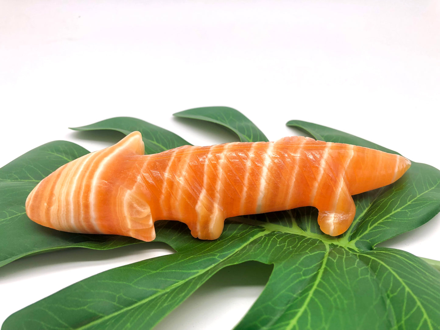 Orange calcite lizard carving