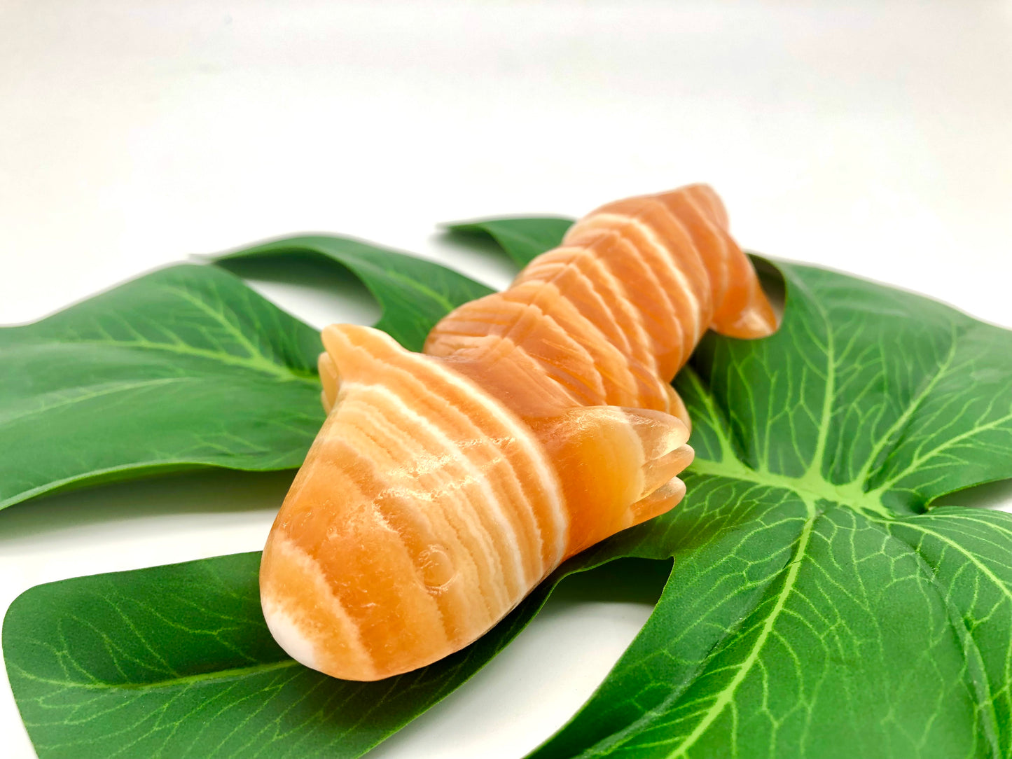 Orange calcite lizard carving